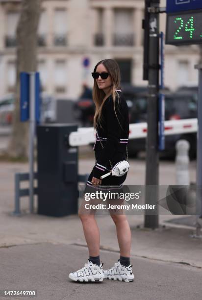 Charlotte Groeneveld seen wearing black and white Nike Air shoes, a matching knit set with a cardigan and a mini skirt, two white leather bags and...