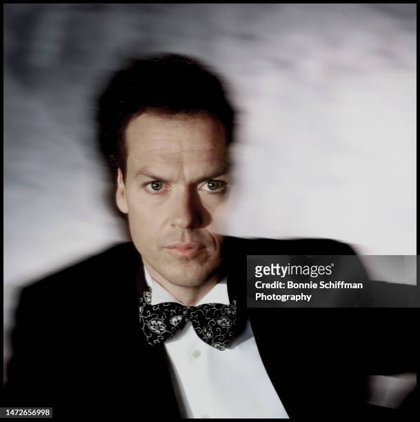 Actor Michael Keaton faces camera in a suit and bowtie amidst haze in Los Angeles in 1989.