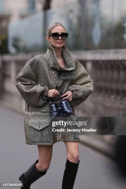 Leonie Hanne is seen wearing a grey long coat, black leather high boots, black sunglasses, mini Louis Vuitton navy handbag outside the Louis Vuitton...