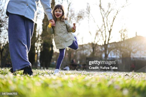 niño jugando con la madre al aire libre y tomados de la mano. - marzo fotografías e imágenes de stock