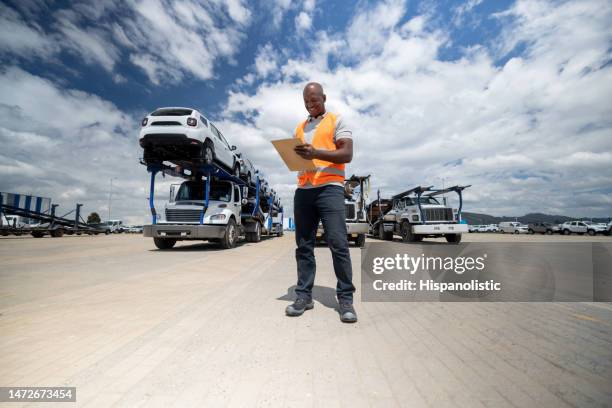 man supervising the shipping of cars to the dealerships - african lorry stock pictures, royalty-free photos & images