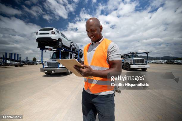 man managing the shipping of cars to the dealerships - biltransporttrailer bildbanksfoton och bilder