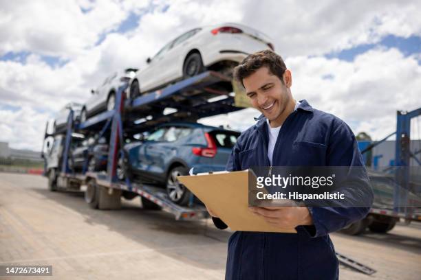 man working at a commercial dock and shipping cars to the dealerships - biltransporttrailer bildbanksfoton och bilder