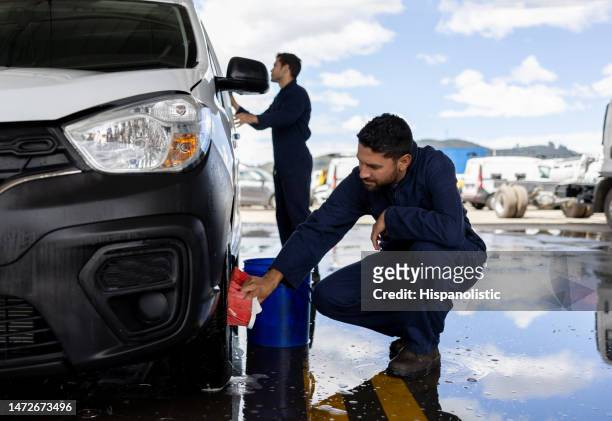 hombres trabajando en un lavado de autos limpiando un vehículo - car wash brush fotografías e imágenes de stock