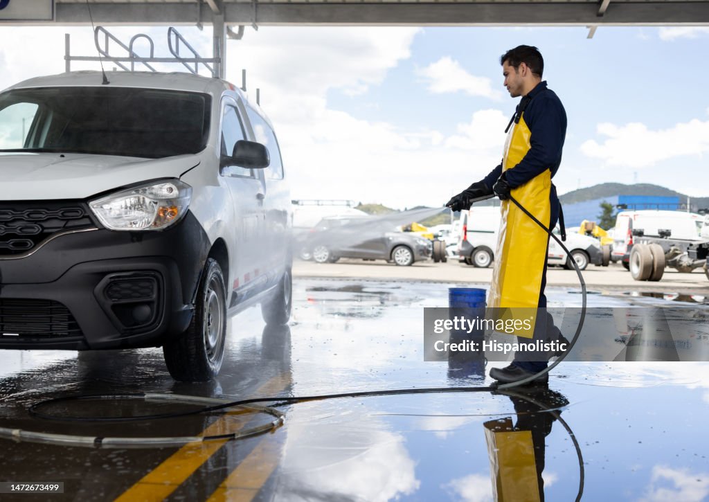 Man working at a car wash and using a high-pressure hose