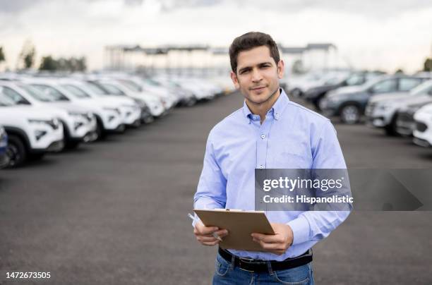 salesman using a tablet at a car dealership - car fleet stock pictures, royalty-free photos & images