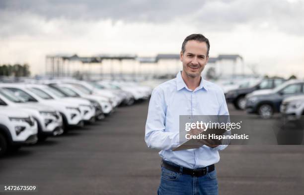 porträt eines verkäufers, der im freien in einem autohaus arbeitet - fleet cars stock-fotos und bilder