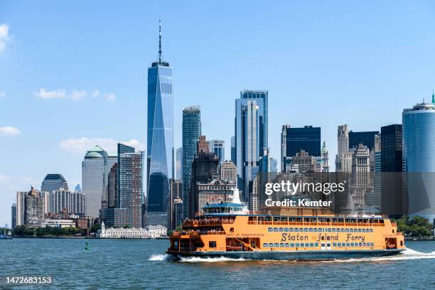 staten island ferry in front of the new york city skyline - staten island ferry stockfoto's en -beelden