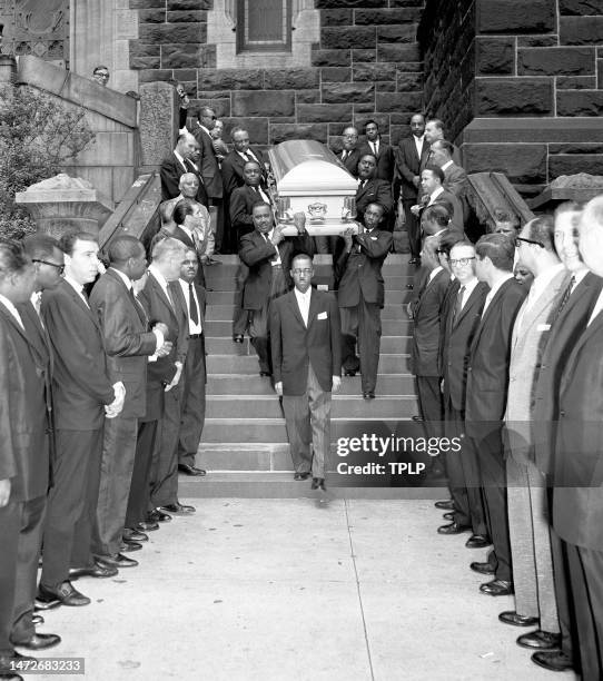 Men line up as the casket with the remains of American jazz and swing music singer Billie Holiday is carried to the hearse from St. Paul the Apostle...