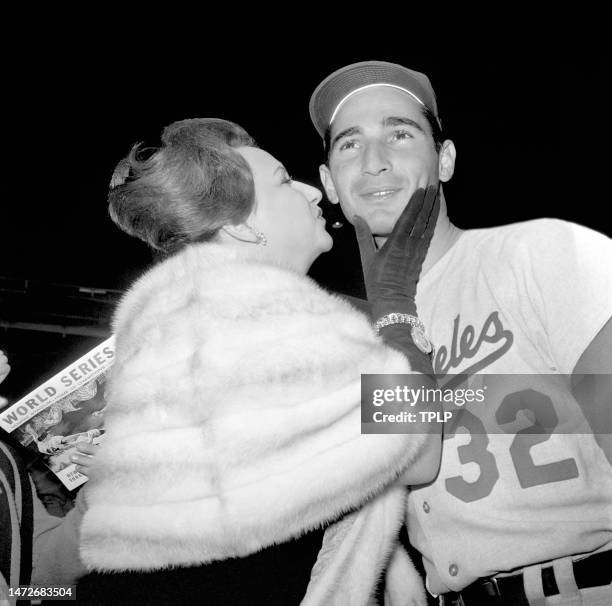 Pitcher Sandy Koufax of the Los Angeles Dodgers is kissed by Joan Hodges, wife of Gil Hodges, after Game 2 of the 1963 World Series at Yankee Stadium...