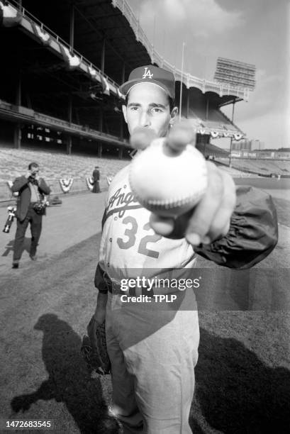 Pitcher Sandy Koufax of the Los Angeles Dodgers shows how he grips a baseball during practice prior to Game 1 of the 1963 World Series at Yankee...