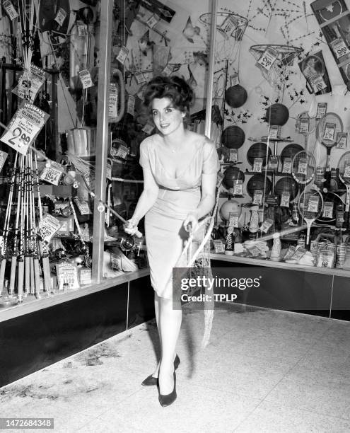 American actress Tina Louise poses for a portrait with a fishing pole and net as she lends her support to help promote sporting goods sales in New...