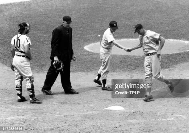 Stan Musial of the St. Louis Cardinals and the National League is greeted by the batboy after hitting a home run as catcher Sherm Lollar of the...