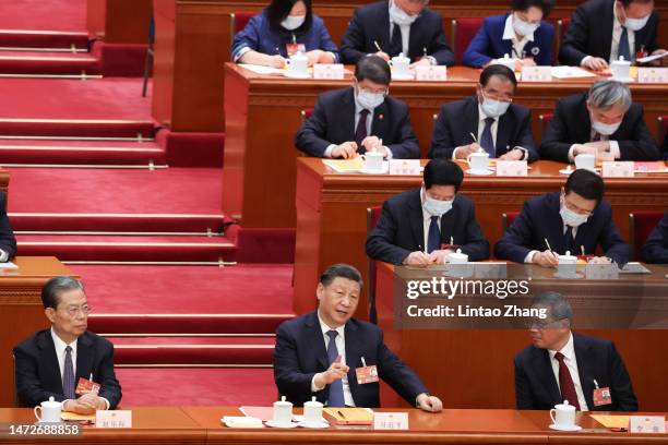 Chinese President Xi Jinping speaks with Politburo Standing Committee member Li Qiang and Politburo Standing Committee member Zhao Leji during the...