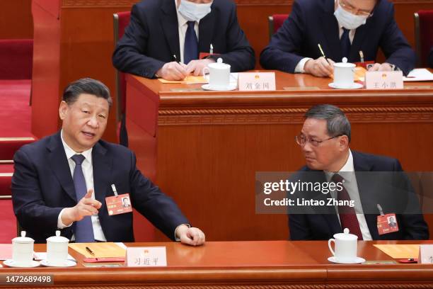 Chinese President Xi Jinping speaks with Politburo Standing Committee member Li Qiang during the opening of the fourth plenary session of the...
