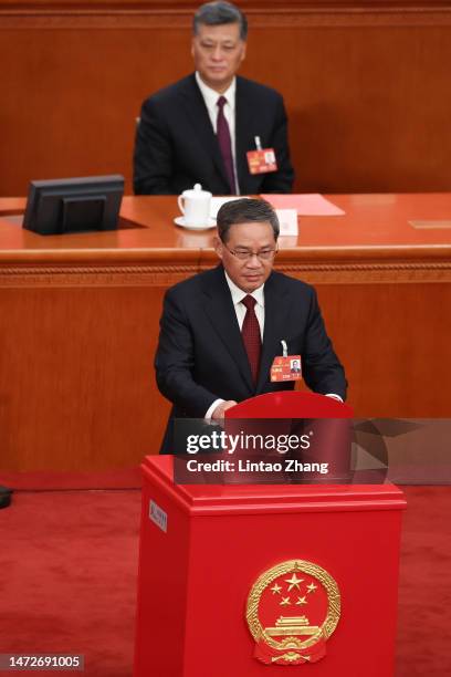 Politburo Standing Committee member Li Qiang votes during the opening of the fourth plenary session of the National People's Congress on March 11,...