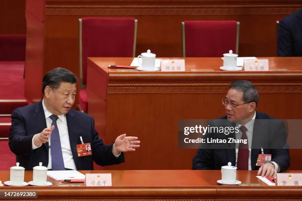 Chinese President Xi Jinping speaks with Politburo Standing Committee member Li Qiang during the opening of the fourth plenary session of the...