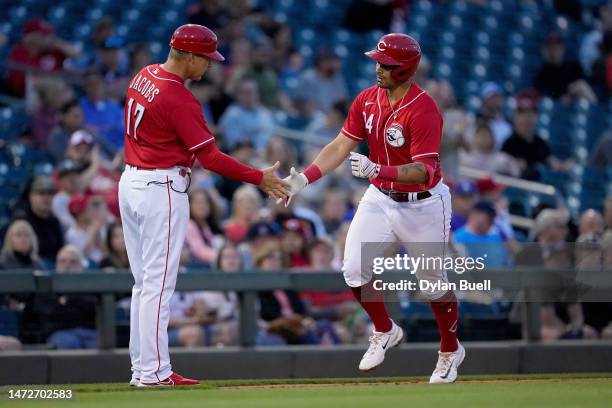 Coach Mike Jacobs and Christian Encarnacion-Strand of the Cincinnati Reds celebrate after Encarnacion-Strand hit a home run in the first inning...