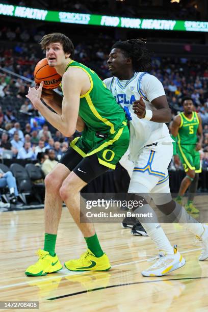Nate Bittle of the Oregon Ducks handles the ball against Will McClendon of the UCLA Bruins in the first half of a semifinal game of the Pac-12...