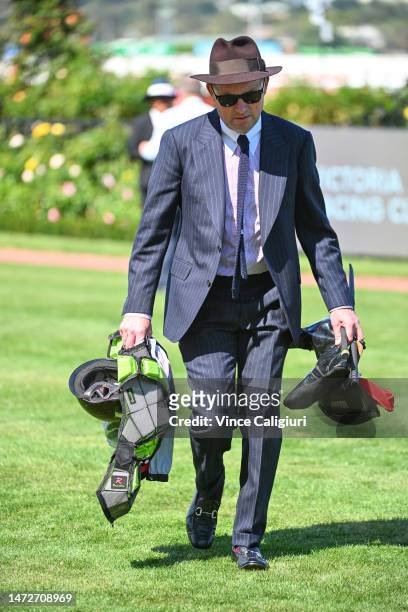 Matt Hyland, Executive officer Victorian Jockeys Association walks back to mounting yard with Craig Williams riding gear after a fall in Race 4, the...