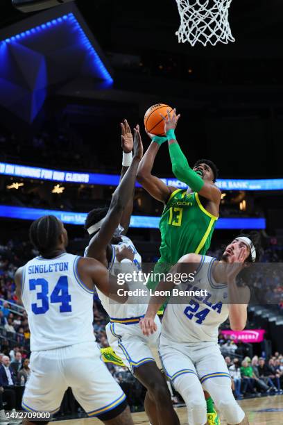 Quincy Guerrier of the Oregon Ducks goes to the basket against Adem Bona and Jaime Jaquez Jr. #24 of the UCLA Bruins in the first half of a semifinal...