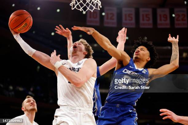 Adam Kunkel of the Xavier Musketeers goes to the basket as Trey Alexander of the Creighton Bluejays reacts during the second half in the Semifinal...