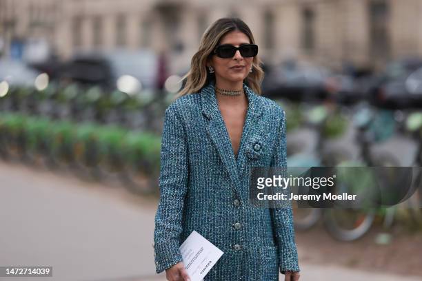 Fashion week guest seen wearing dark shades, silver earrings, a necklace and a blue sequins coat before the Chanel show on March 07, 2023 in Paris,...