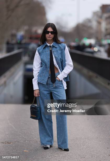 Alizee Gamberini seen wearing a denim look with a west and oversized jeans, a white oversized blouse, white and black shoes, a black necktie, black...