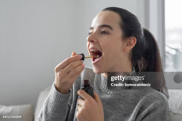 woman using cbd oil - marijuana herbal cannabis stockfoto's en -beelden