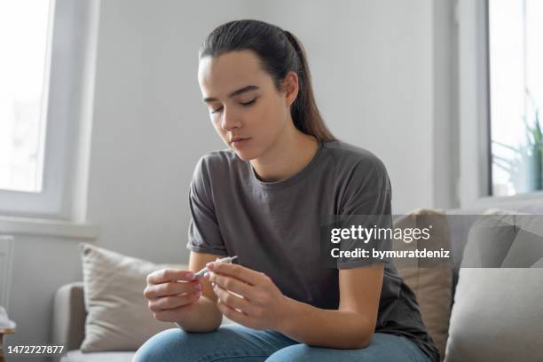 woman using marijuana at home - hashish stockfoto's en -beelden