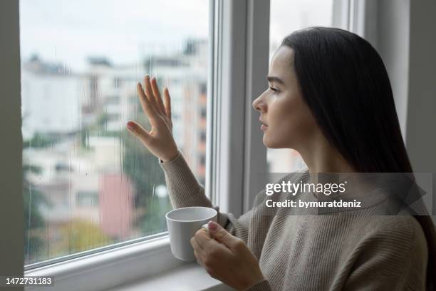 einsame frau, die sich allein fühlt und negative emotionen - winterdepression stock-fotos und bilder