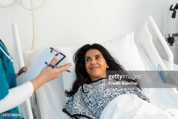 female doctor and female patient talking in hospital - project heal stockfoto's en -beelden