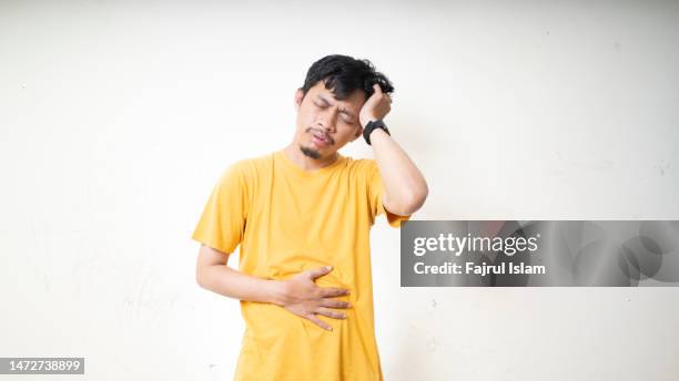 young man got headache and stomachache - gastroentérite photos et images de collection