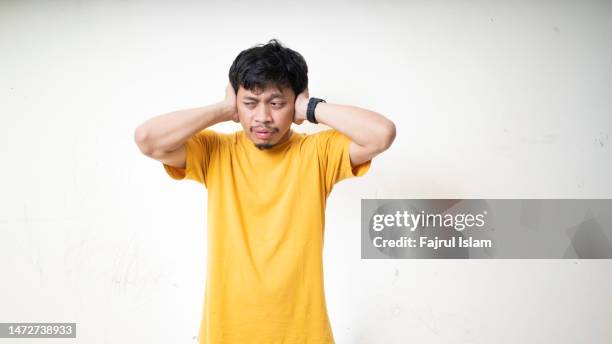 asian man covering his ears - asian man covering ears stock pictures, royalty-free photos & images