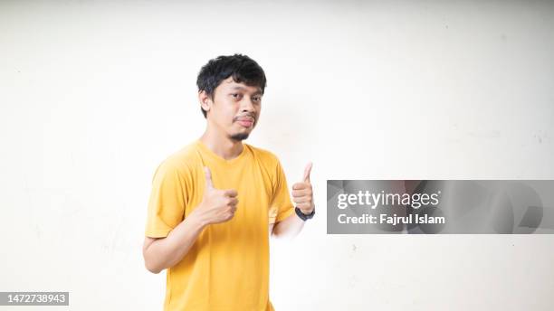 portrait of a handsome young man gesturing thumbs up - asiatischer mann freigestellt stock-fotos und bilder