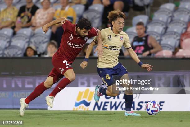 Javi López of Adelaide United competes for the ball with Manabu Saitō of the Jets during the round 20 A-League Men's match between Newcastle Jets and...