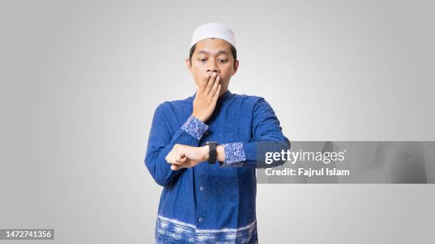 young asian looking at watch and surprised - fajrul islam stock pictures, royalty-free photos & images