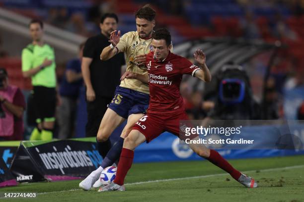 Louis D'Arrigo of Adelaide United competes for the ball with Carl Jenkinson of the Jets during the round 20 A-League Men's match between Newcastle...