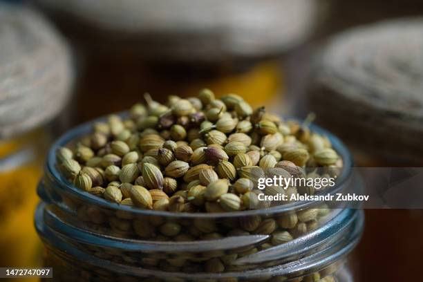 spices and herbs standing in a row on a wooden table or shelf. dried crushed spices and seasonings in glass jars and containers with inscriptions in the kitchen cabinet or pantry, storage of bulk products. the concept of cooking, home decor. - cardamom stock pictures, royalty-free photos & images