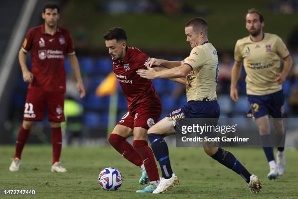 Zach Clough of Adelaide United competes for the ball with Brandon O'Neill of the Jets during the round 20 A-League Men's match between Newcastle Jets...
