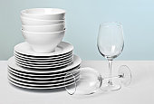 White dishes and crystal wine glasses on varied blue background