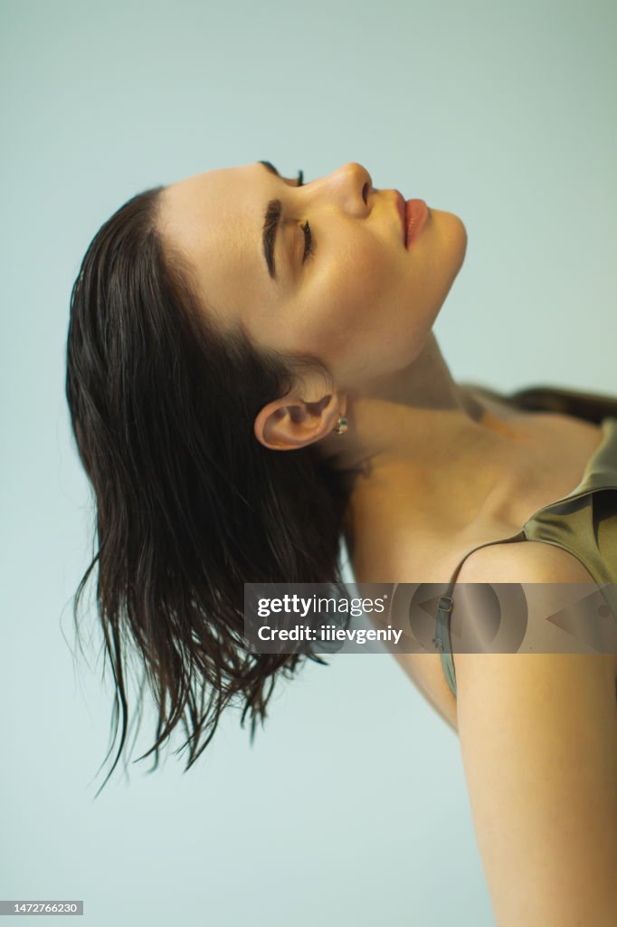 Asian woman in dress in studio on white background. Natural beauty