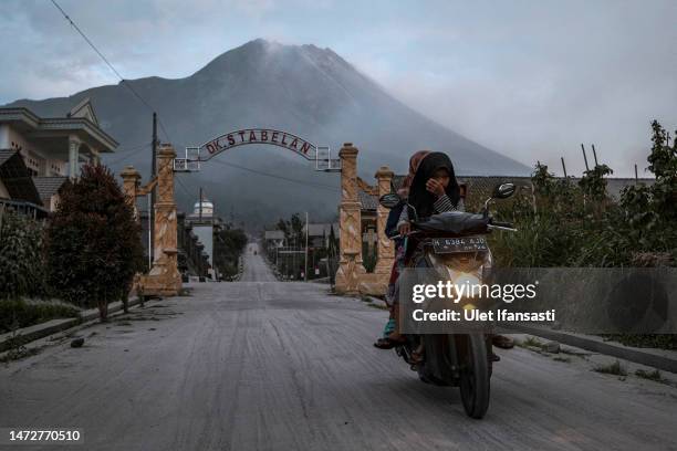 Motorcyclist wearing a mask rides past in an area covered by ash after Mount Merapi erupted spewing volcanic materials at Stabelan village on March...