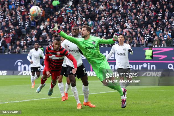 Kevin Trapp of Eintracht Frankfurt makes a save whilst under pressure from Juan Jose Perea of VfB Stuttgart during the Bundesliga match between...