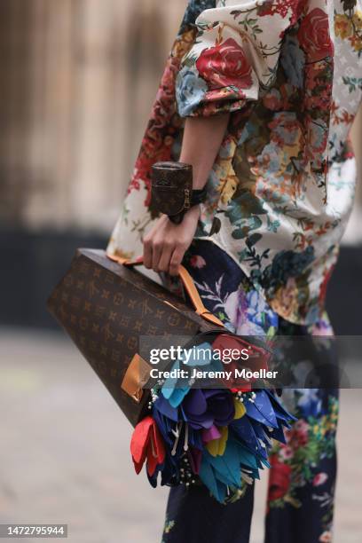 Fashion Week guest is seen wearing flower print shirt, multicoloured flower print Louis Vuitton pants, a brown LV monogram print pattern with...