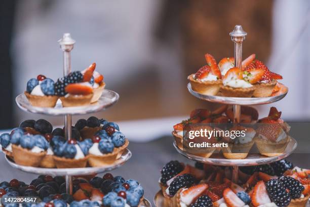 mini tarts with strawberry and blue berries at a celebration buffet - portion stock pictures, royalty-free photos & images