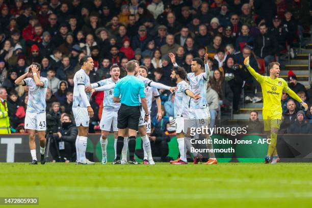 Liverpool player surround Referee John Brooks looking for a penalty against Adam Smith of Bournemouth during the Premier League match between AFC...