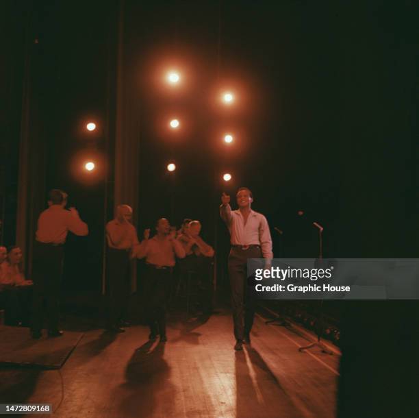 American singer, actor and civil rights activist Harry Belafonte smiles and points while on stage with musicians at the Greek Theater in Los Angeles,...