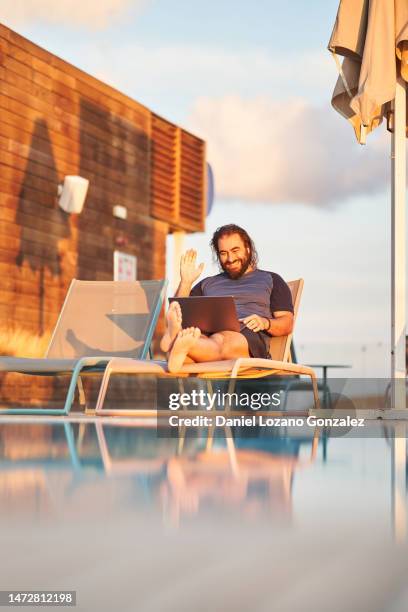 man weaving during an online meeting sitting on a pool - the nomad hotel stock pictures, royalty-free photos & images