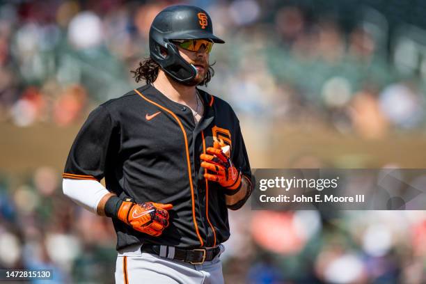 Brandon Crawford of the San Francisco Giants jogs to first base during the second inning of the Spring Training game against the Colorado Rockies at...